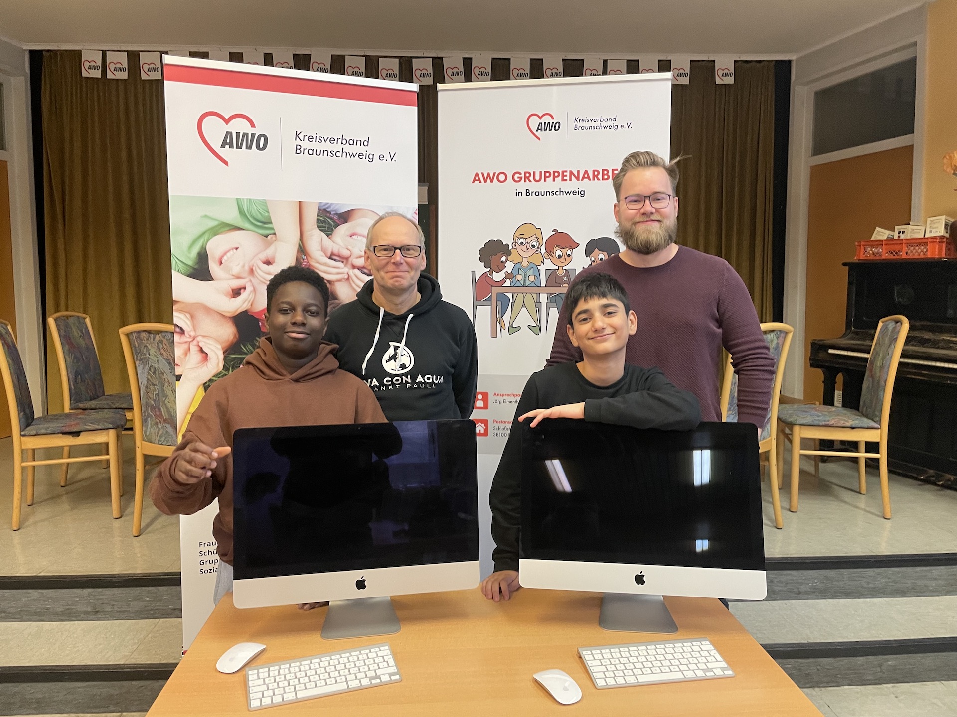 Kooperation zwischen IT Consulting Braunschweig und der AWO Gruppenarbeit. Fröhliche Kinder und IMacs.